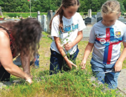 Family pulling weeds at grave